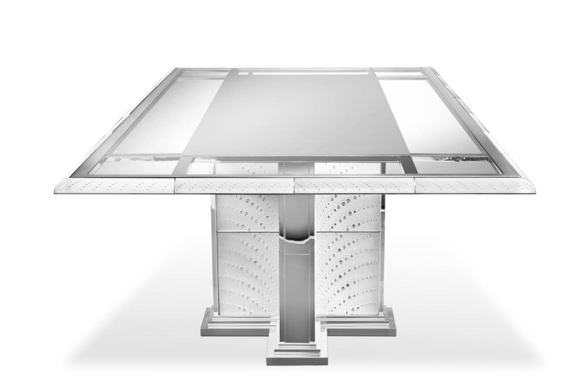 sleek modern dining table with glass top and metal base in a bright setting