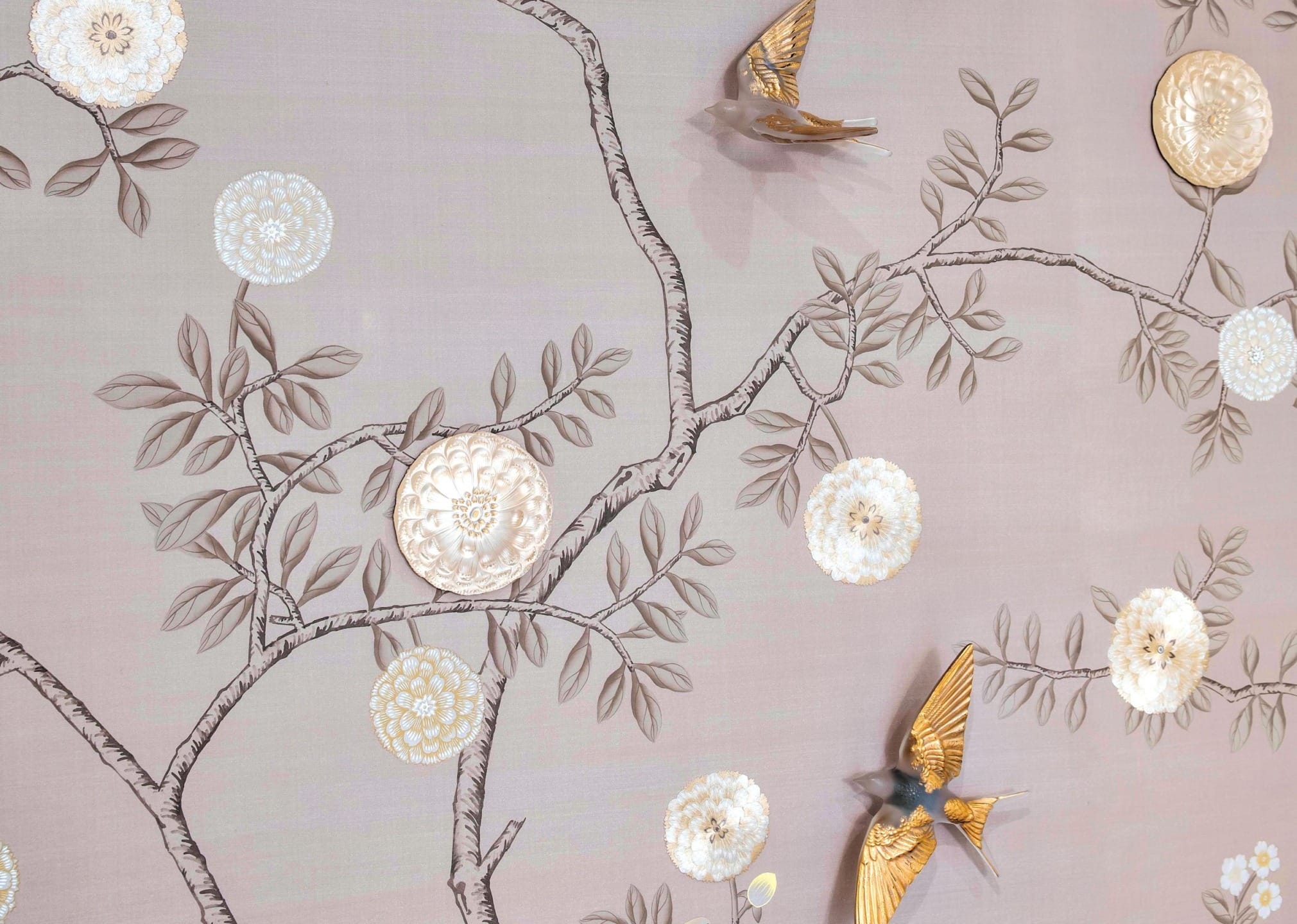 Wall design with textured branches, white flowers, and golden birds on a light beige background.