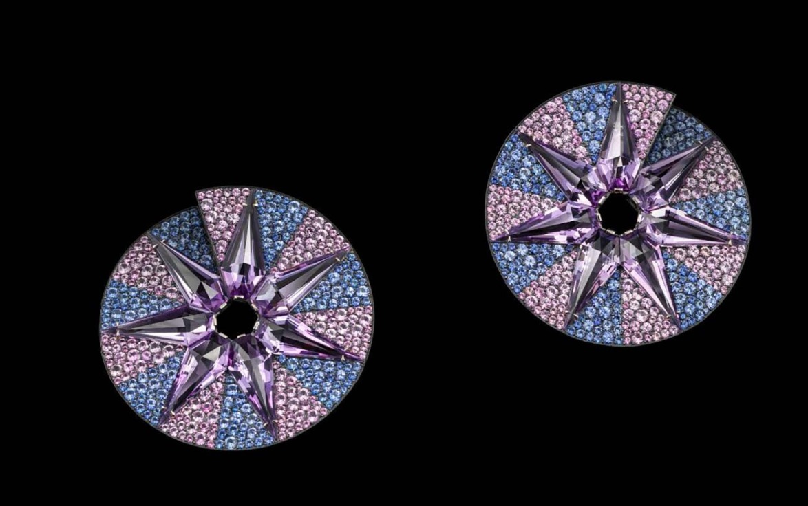 Circular starburst earrings with purple, pink, and blue crystals on a black background.