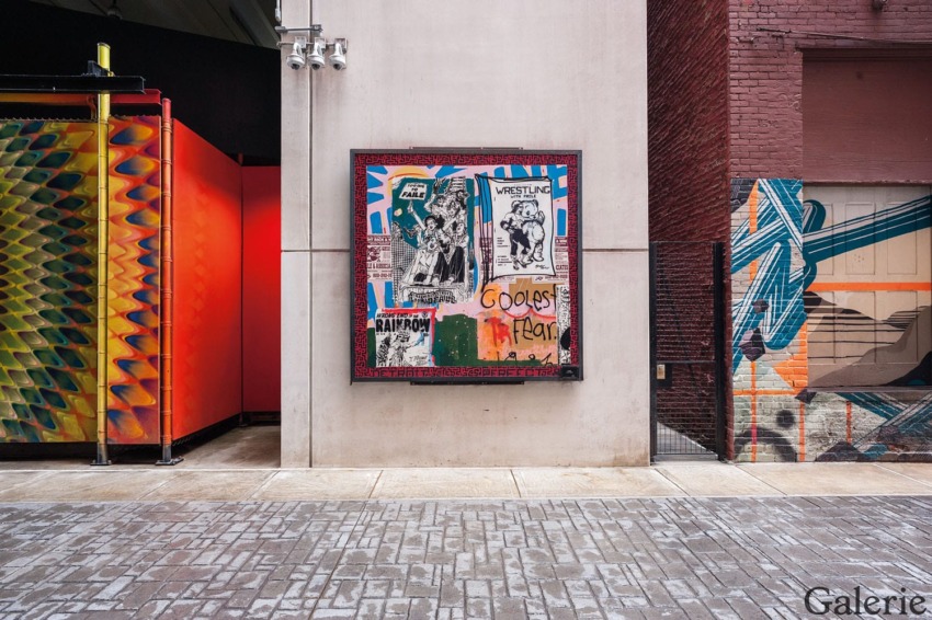 Colorful urban artwork displayed in an alley with vibrant graffiti and posters on the walls.