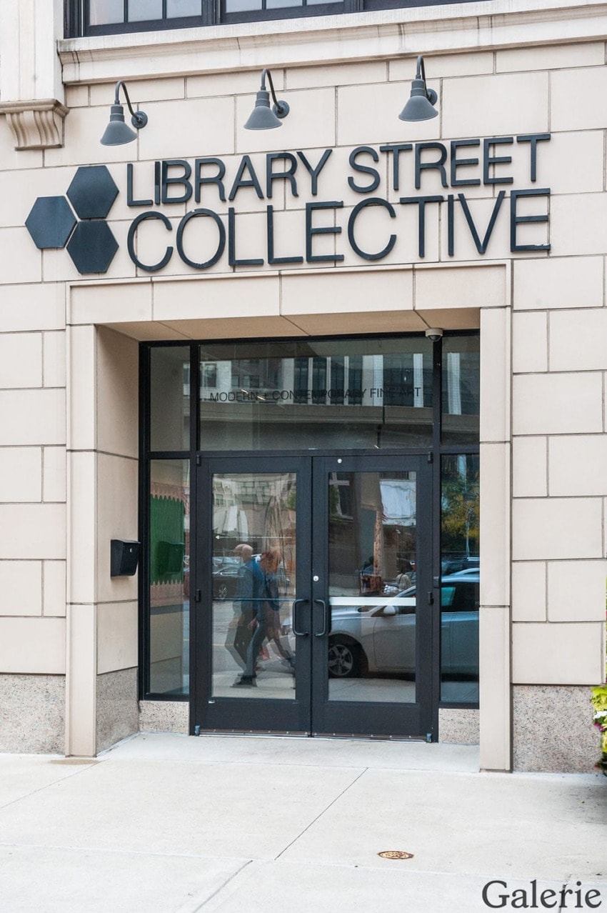 Entrance of Library Street Collective gallery with glass doors and modern sign on an urban street.