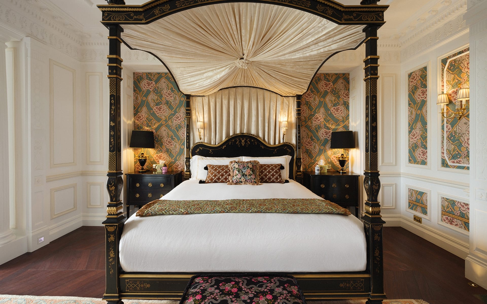 Elegant bedroom with a luxurious four-poster bed, ornate wallpaper, and classic furnishings.