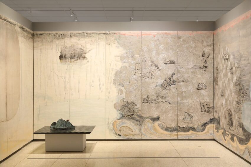 Large, abstract art installation with swirling patterns and muted colors on multiple panels in a well-lit gallery space.