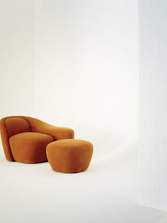 Brown modern armchair with matching ottoman on a white background.