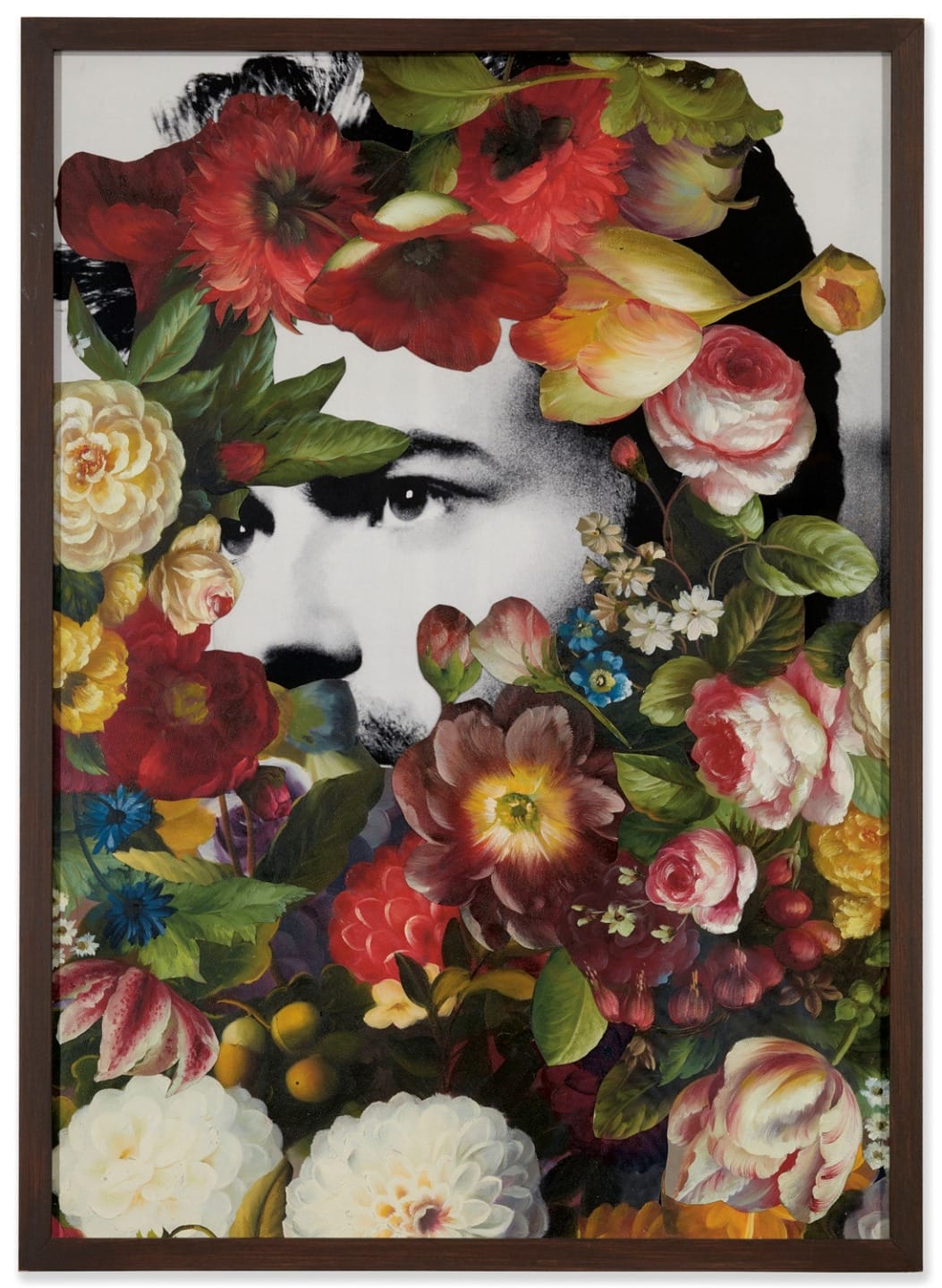 A black and white portrait partially obscured by vibrant, colorful flowers in a wooden frame.