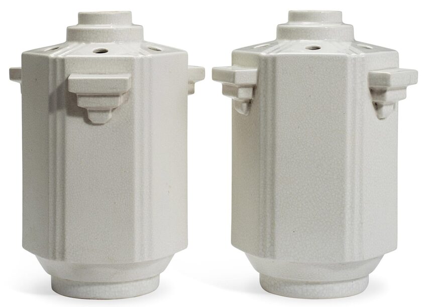 Two white ceramic vases with geometric design, featuring vertical ridges and symmetrical protrusions, art deco style.