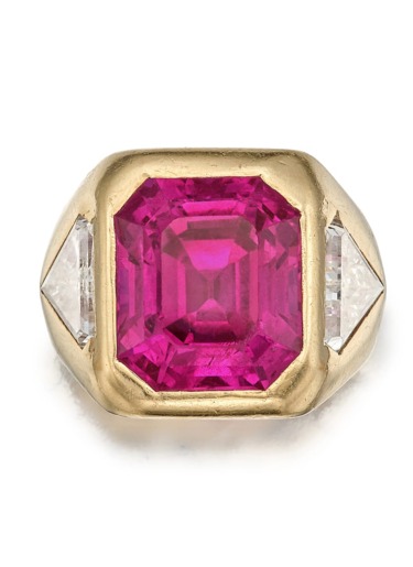 Gold ring with a large square pink gemstone in the center flanked by two triangular white stones on each side.