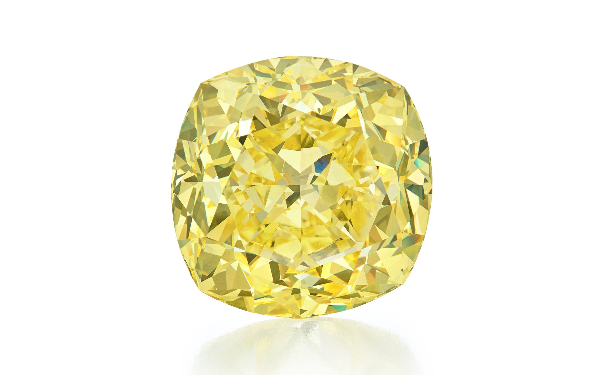 Brilliant yellow diamond with a cushion cut, showcasing intricate facets and vibrant color against a white background.