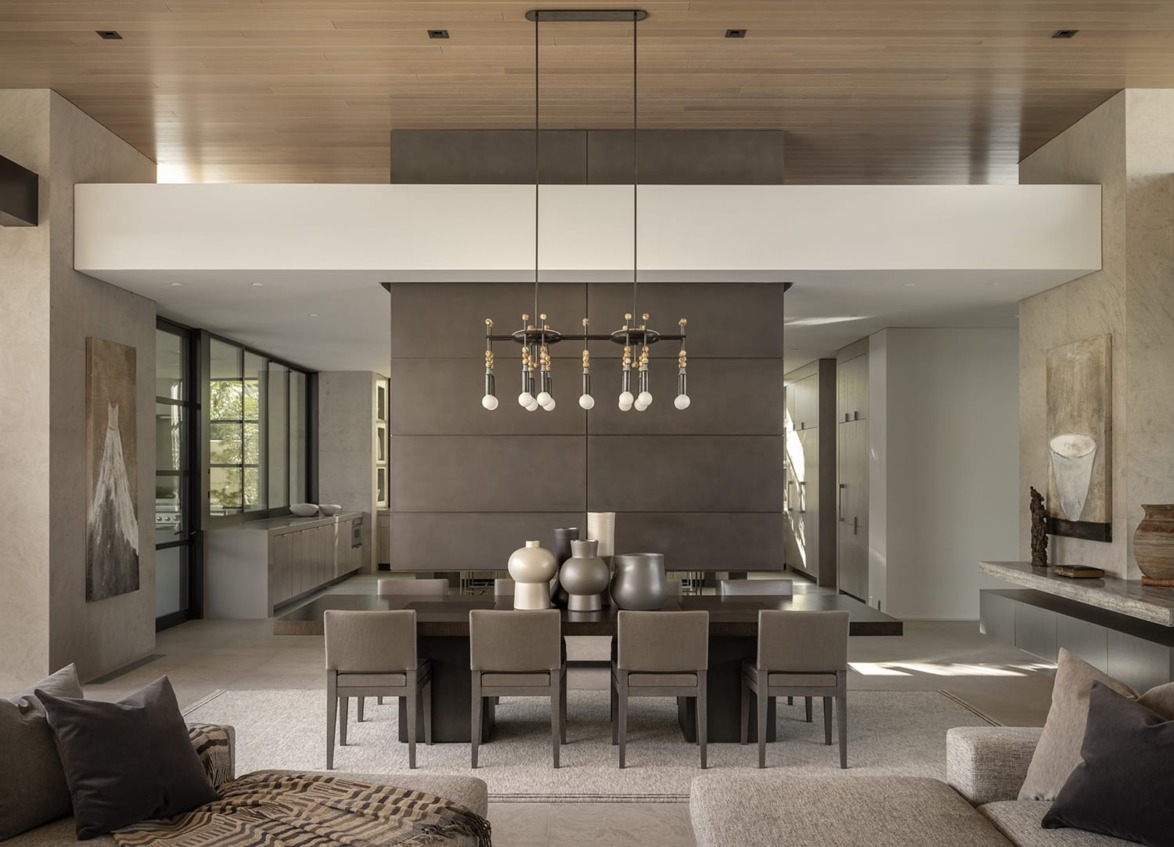 Modern open-concept living dining area with neutral tones, large chandelier, textured walls, and contemporary furniture.
