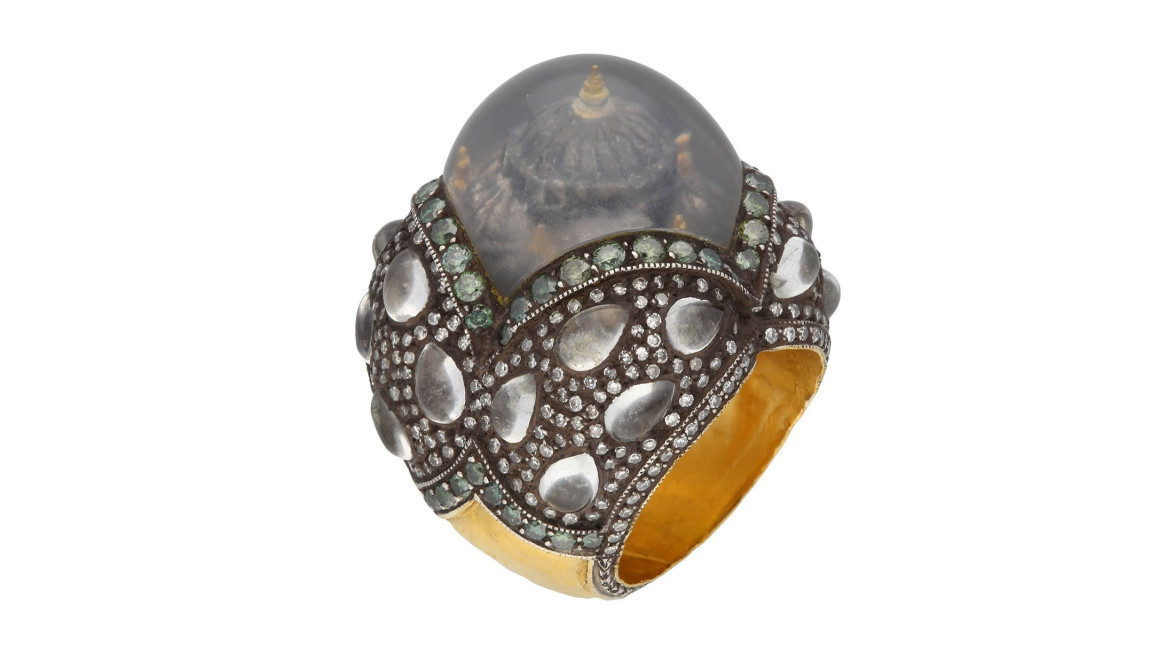 Ornate globe-shaped ring with intricate patterns, emerald accents, and a central dome-like feature.