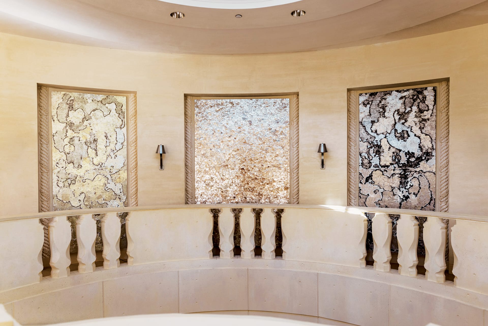 Elegant hallway with beige walls, three artistic wall panels, and decorative railing under a round ceiling.