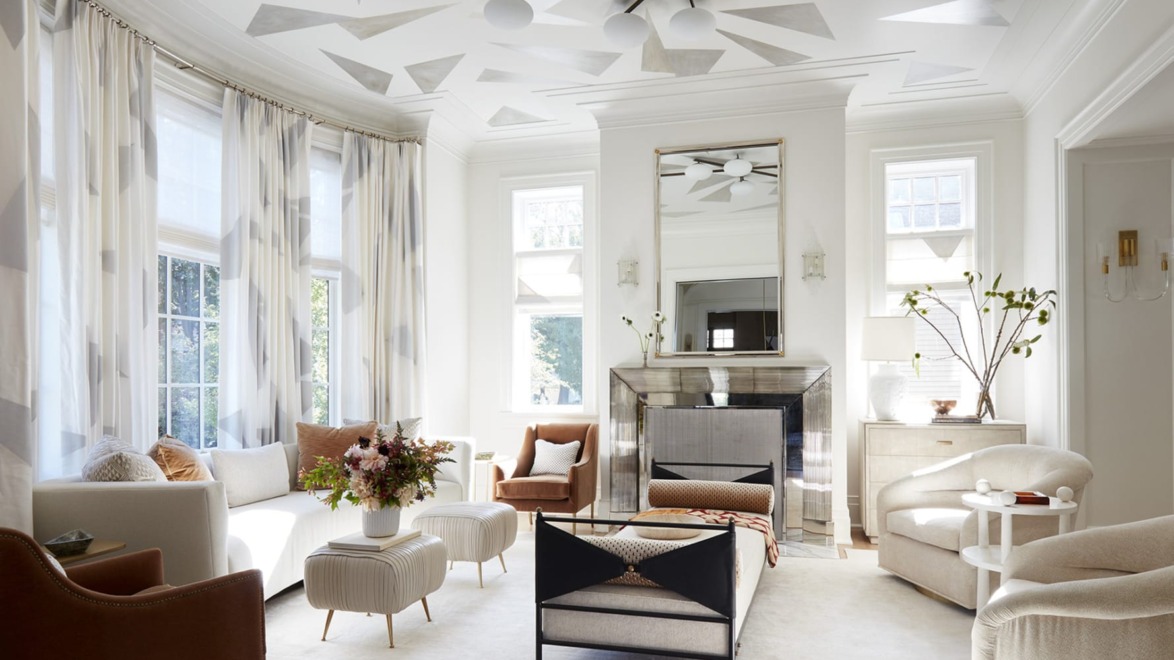 Elegant living room with modern decor, white walls, patterned ceiling, large windows, comfortable seating, and a central coffee table.