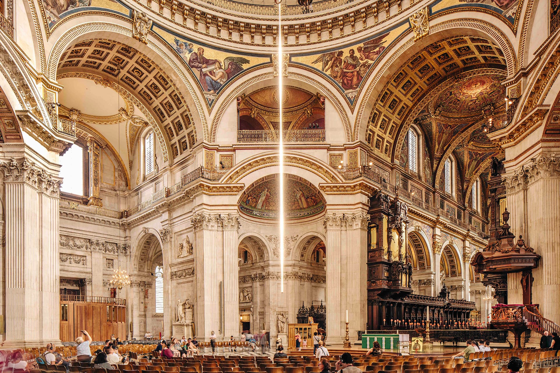 Interior of a grand cathedral with ornate arches, detailed frescoes, and a central beam of light illuminating the space.