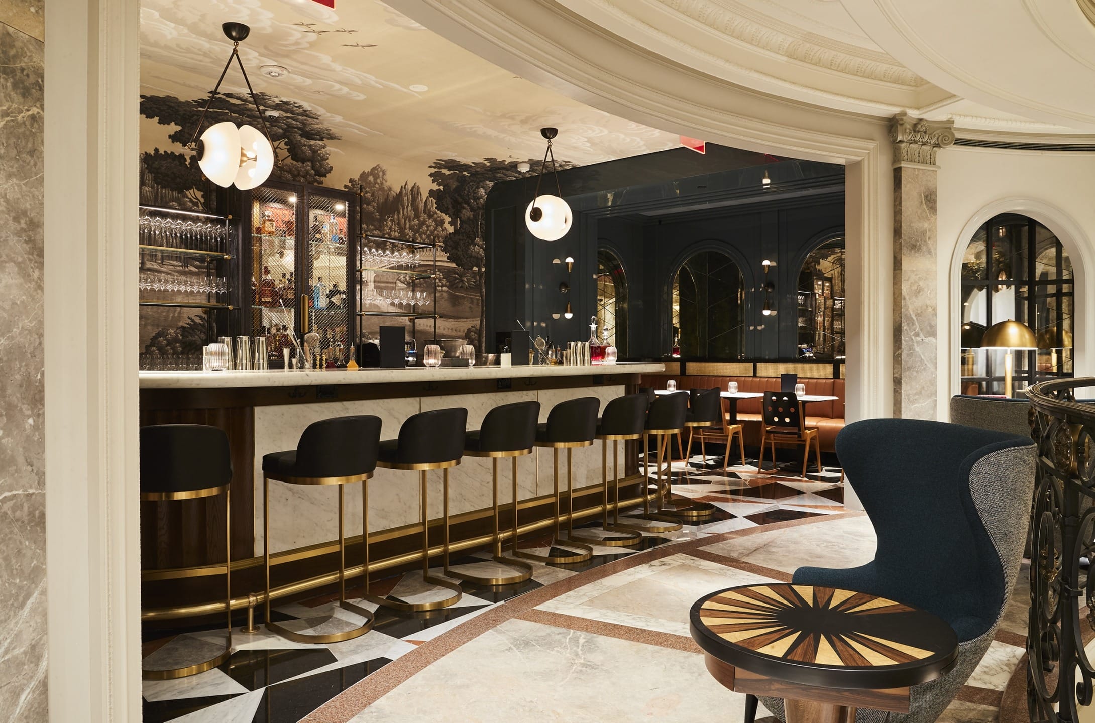 Elegant bar interior with modern lighting, marble accents, and stylish seating in a sophisticated setting.