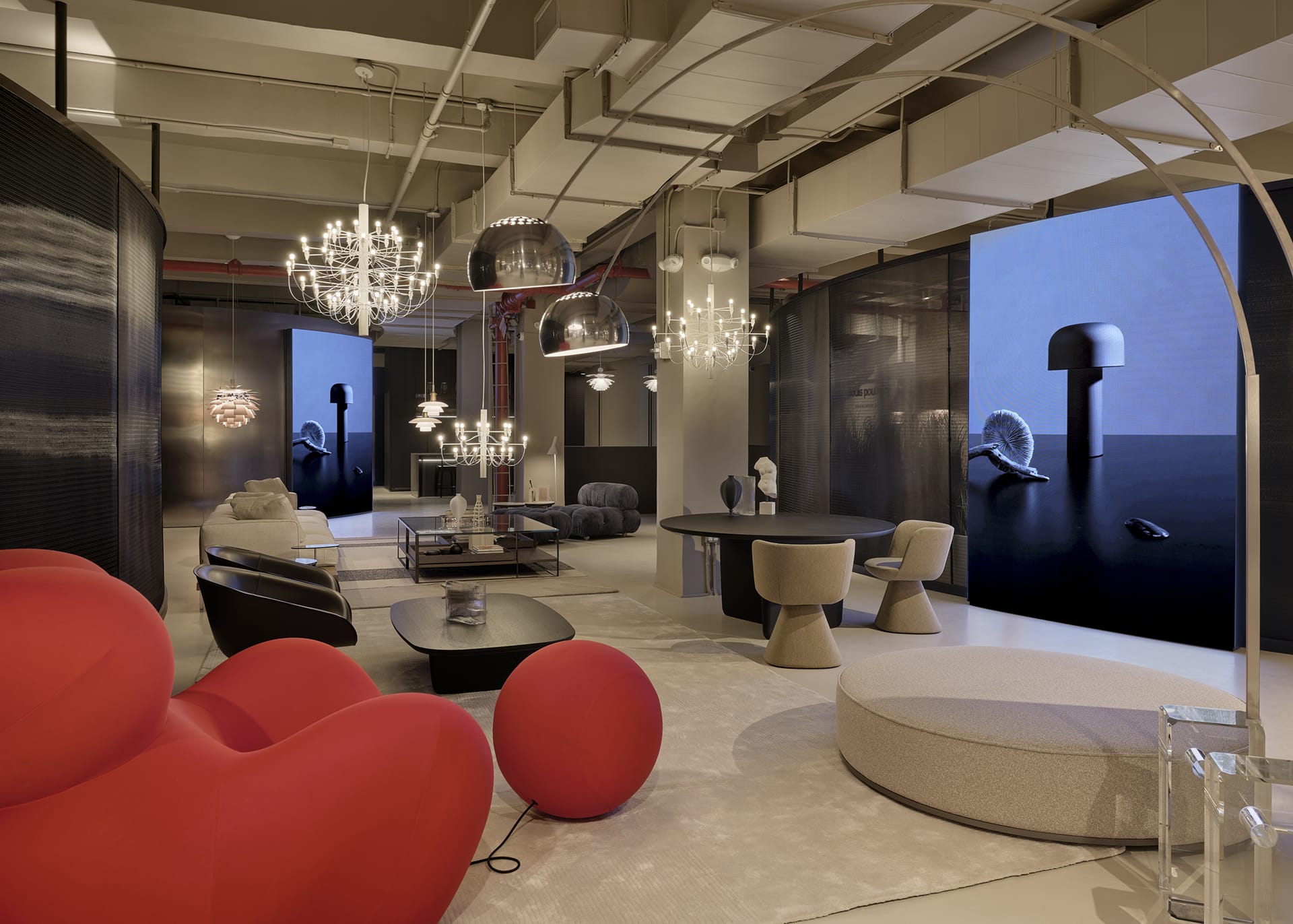 Modern showroom with contemporary furniture, red sofa, unique lighting fixtures, and digital screens showcasing product designs.