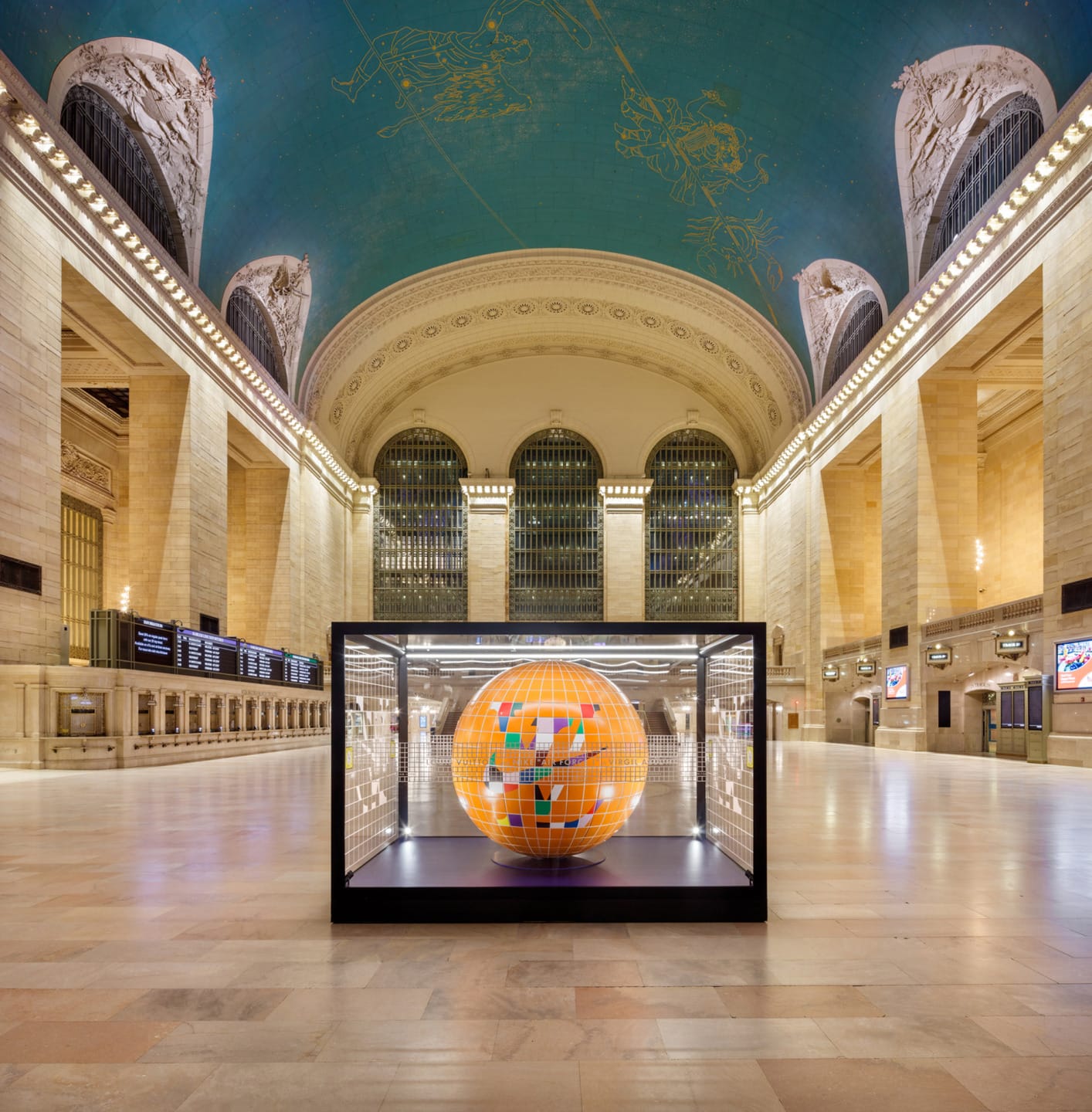 Vibrant art installation of a globe inside a glass case at the spacious and ornate Grand Central Terminal.
