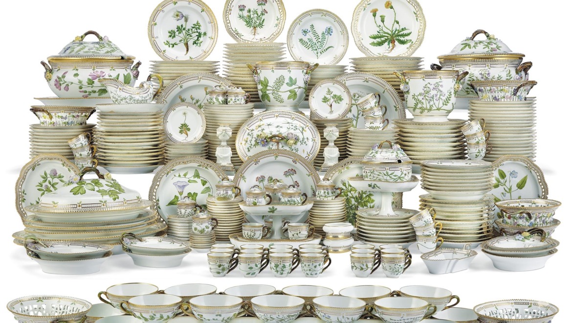 A large collection of elegant porcelain dinnerware with floral patterns, including plates, bowls, teapots, and serving dishes.