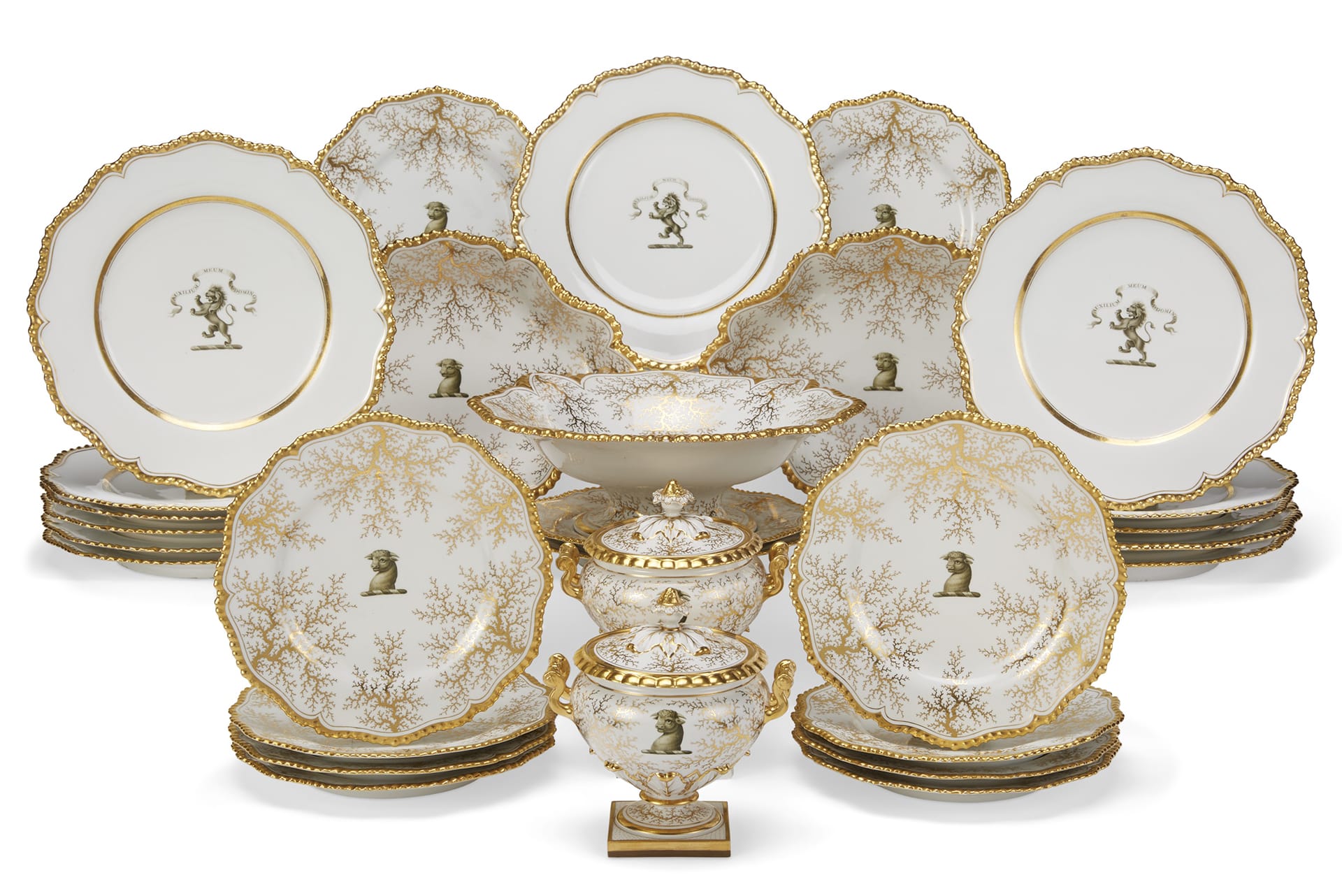 Elegant vintage dinnerware set with gold trim and intricate designs, featuring plates and ornate serving pieces.