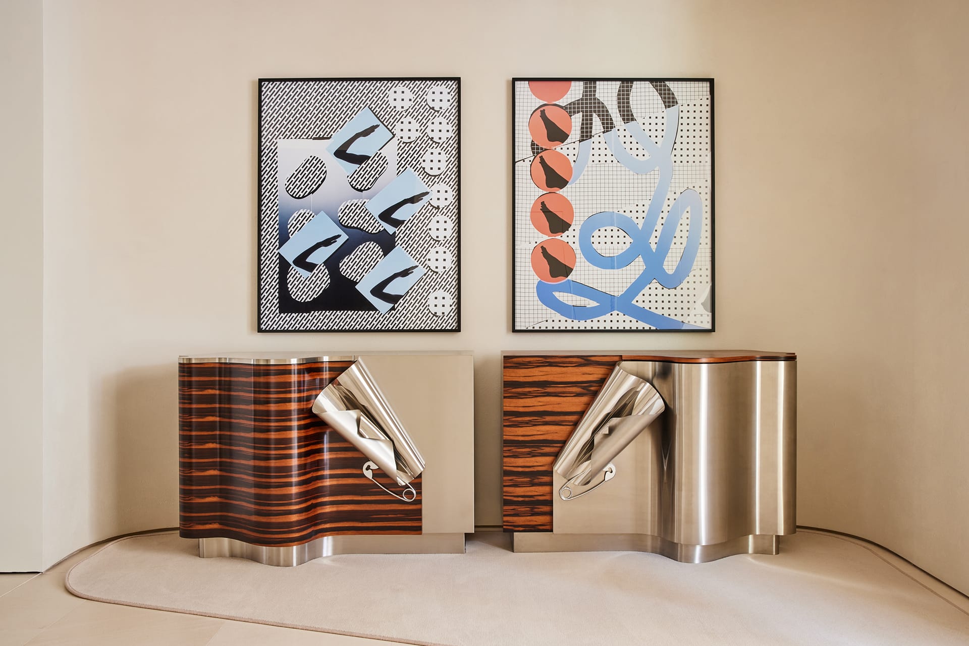 Two modern art pieces above a pair of uniquely designed wooden and metal cabinets in a minimalist room setting.