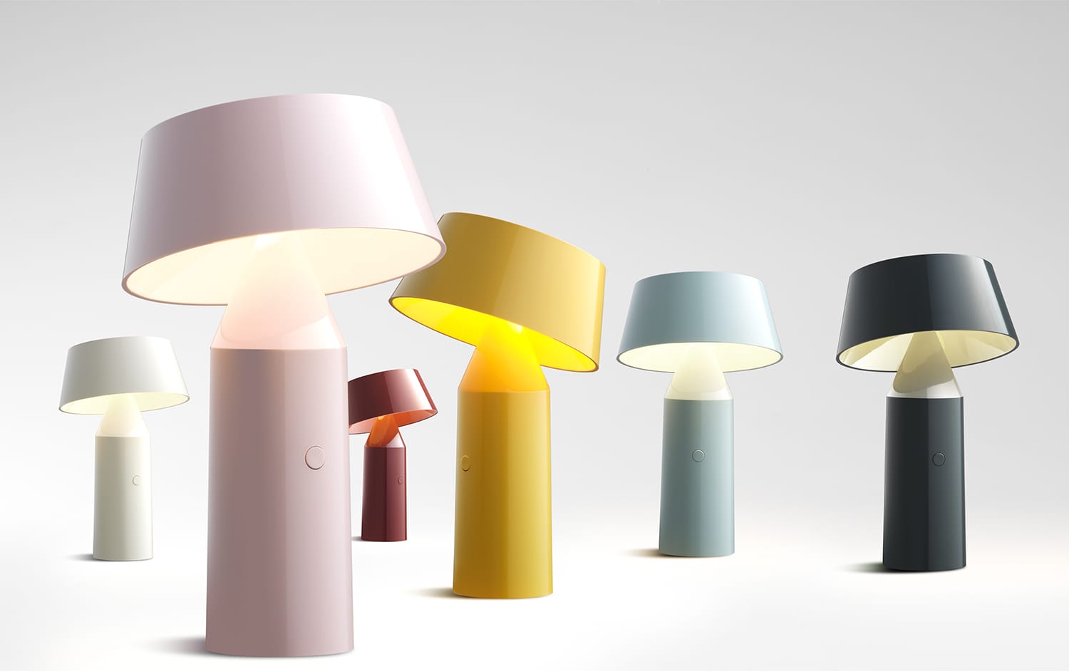 Colorful modern table lamps in various pastel shades displayed against a neutral background.