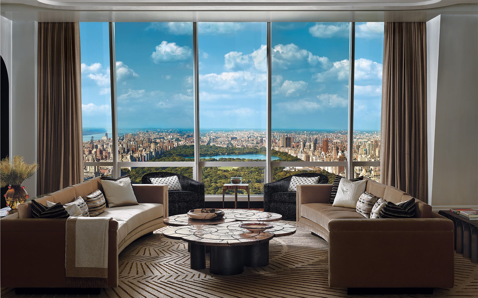 luxurious living room with modern furniture and large windows offering a panoramic view of a cityscape and a central park