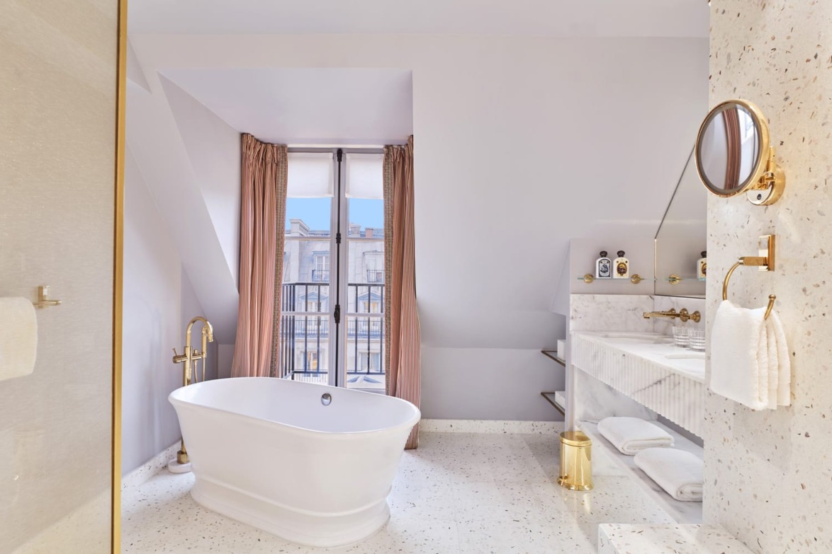 Elegant bathroom with freestanding tub, modern fixtures, large window, and pink curtains.