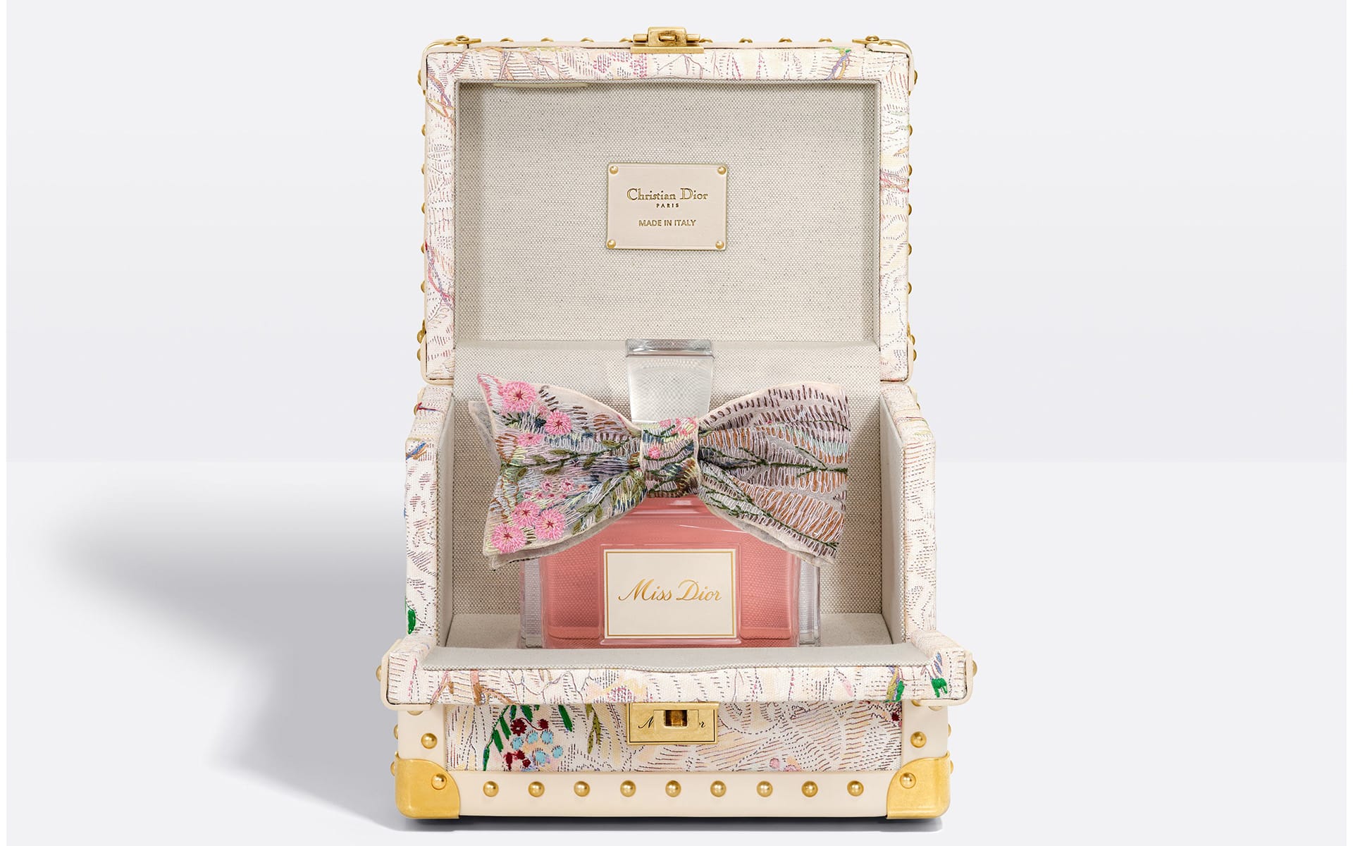 Elegant perfume bottle in designer gift box with floral bow and luxurious detailing.
