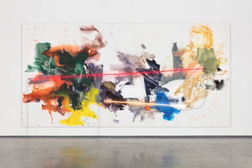 Abstract painting with vibrant splashes of color and a bold red horizontal line across the canvas, displayed on a gallery wall.