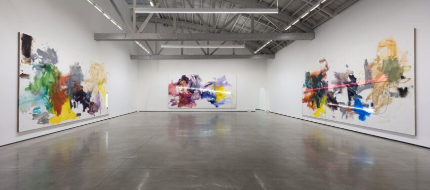 Art gallery interior with abstract paintings on the walls, featuring vibrant colors and diverse brushstrokes.