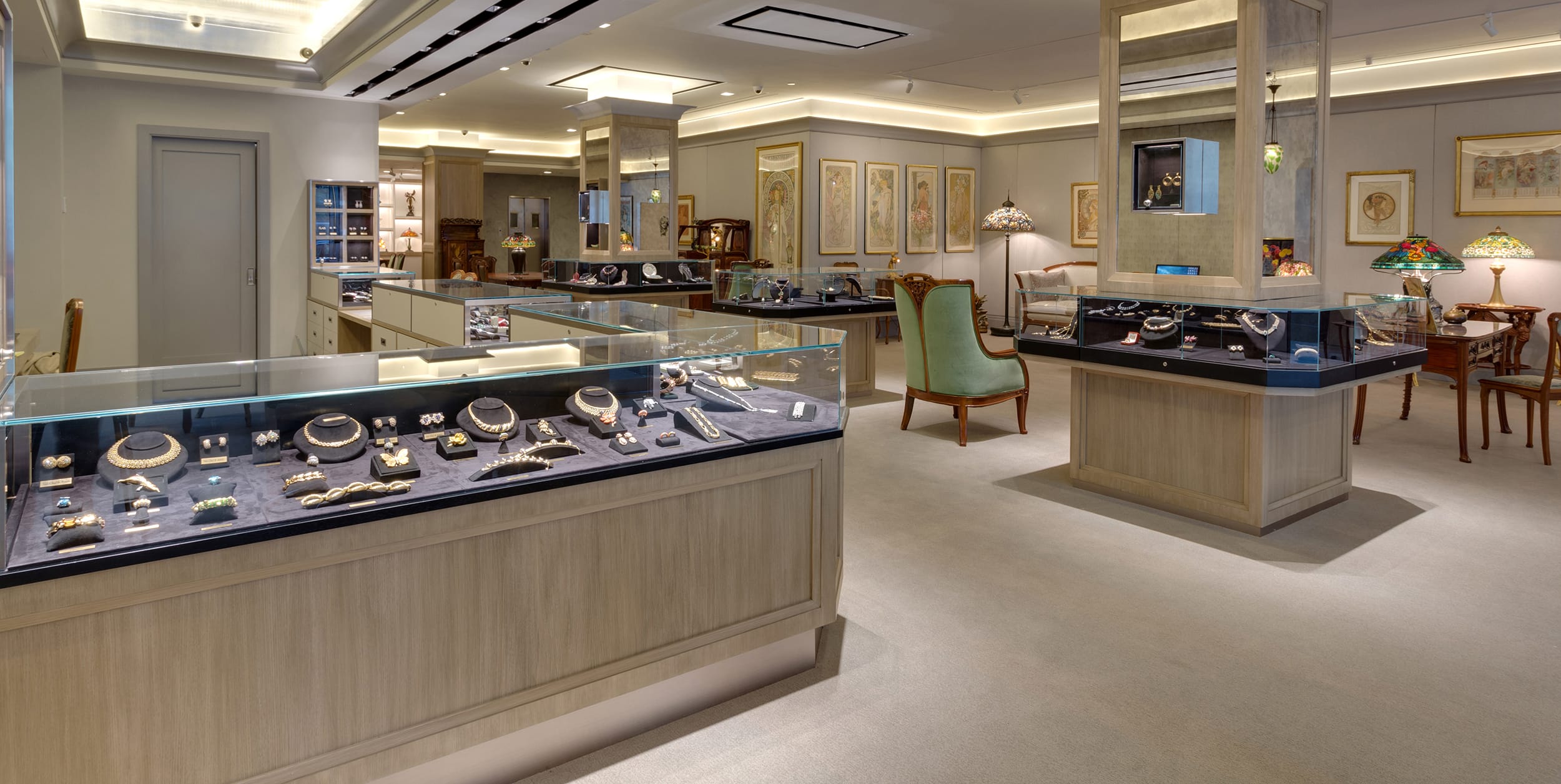 Interior view of a luxurious jewelry store displaying necklaces and watches in glass cases with elegant lighting and decor.