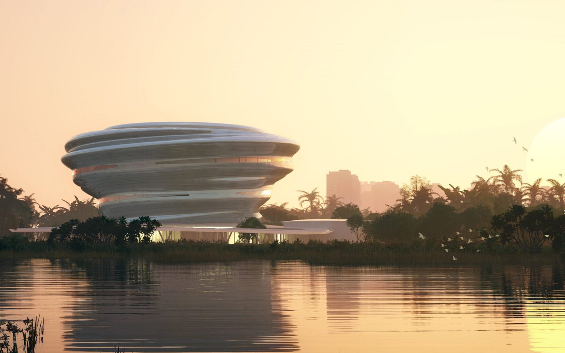 Futuristic building by a lake with a sunset backdrop and distant city skyline surrounded by trees and greenery.