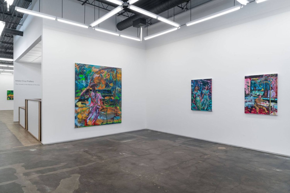 Gallery interior with abstract paintings on white walls and polished concrete floor under bright overhead lights