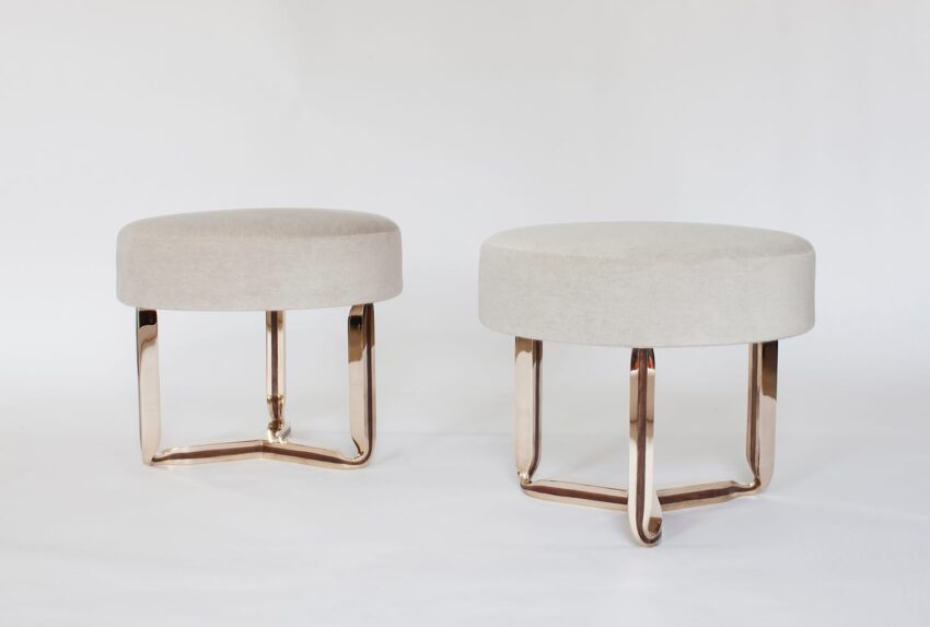 Two modern beige ottomans with metal legs on a white background.
