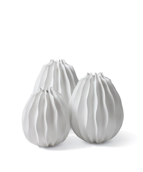 Three white ceramic vases with a ribbed design in varying heights.