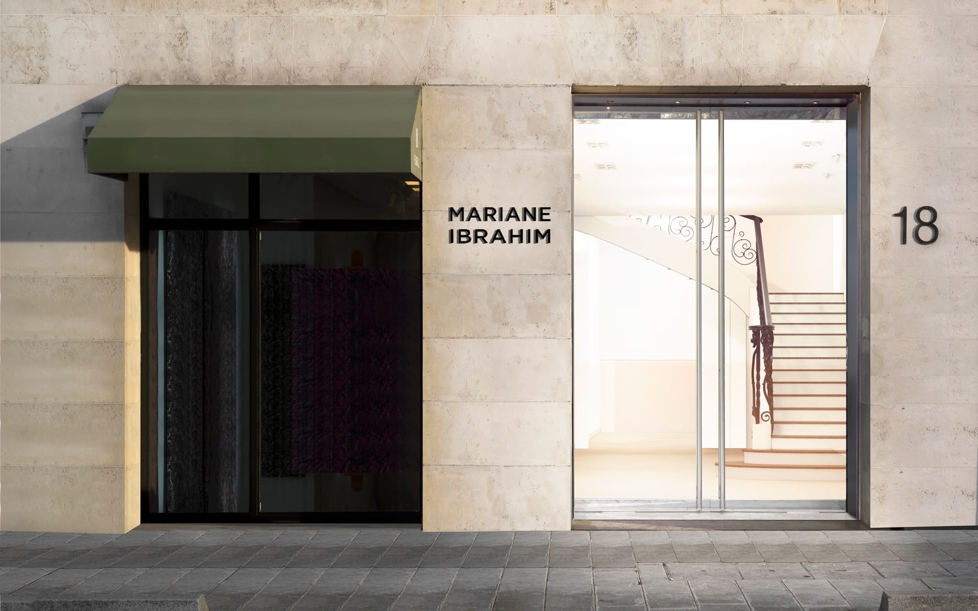 Exterior view of a modern art gallery with glass doors and a sign reading Mariane Ibrahim above, showcasing a curved staircase inside.