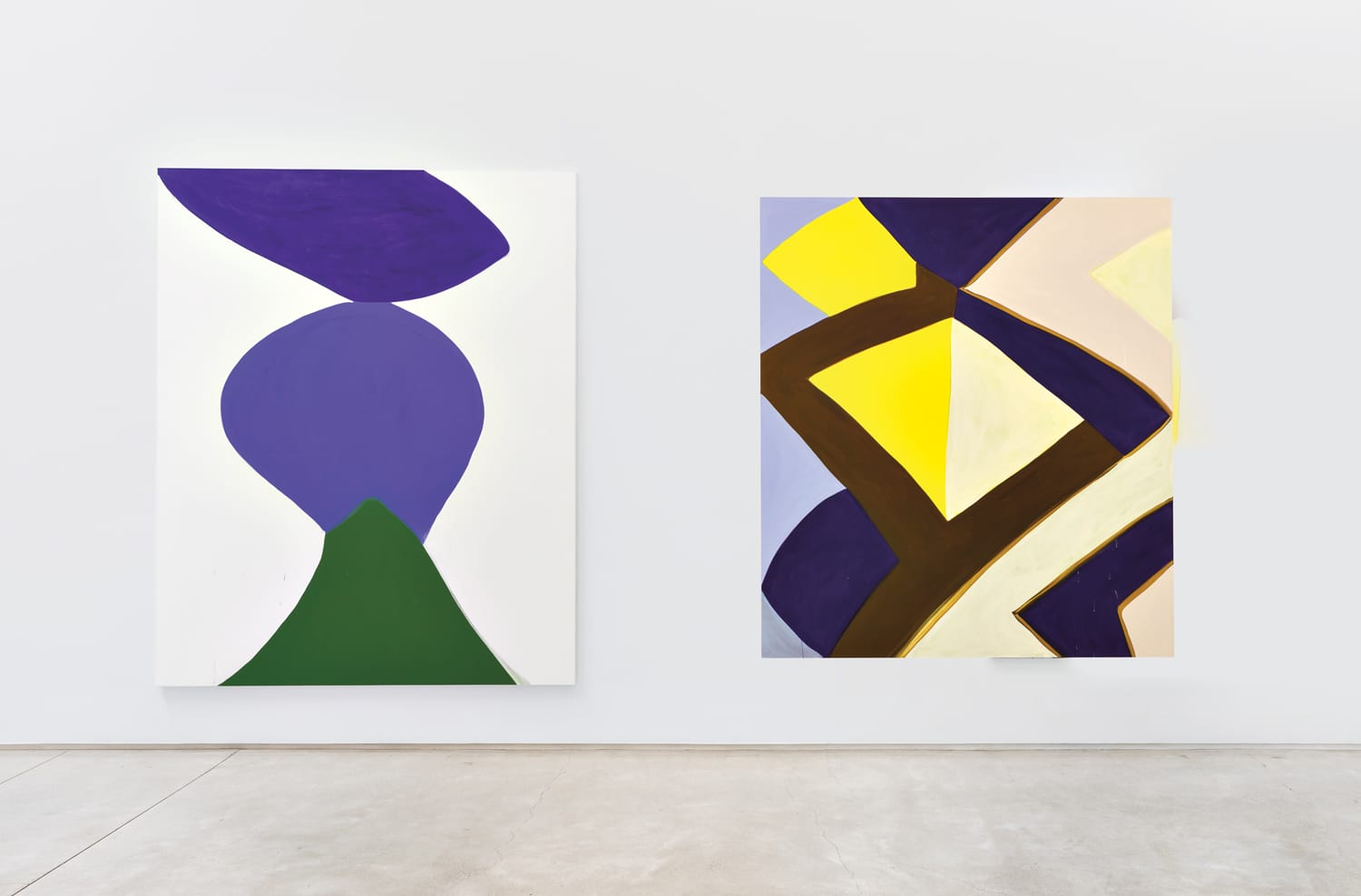 Two abstract paintings with bold geometric shapes in purple, green, yellow, and brown on a gallery wall.