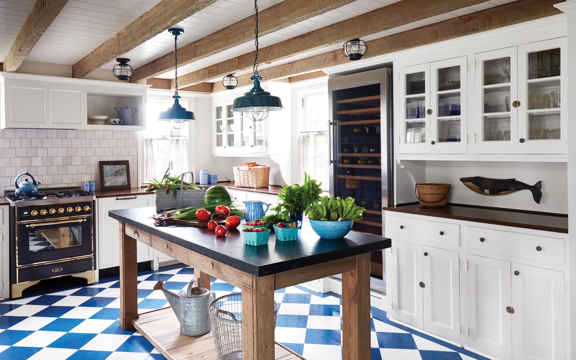 Rustic kitchen with a wooden island, blue checkered floor, vintage stove, and hanging lights.