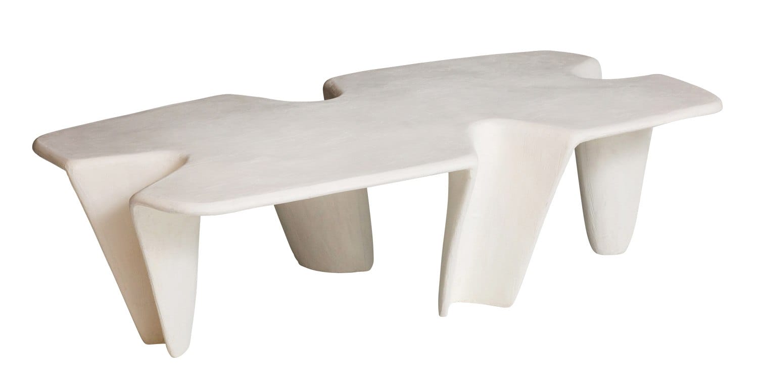 Modern abstract white coffee table with unique sculptural design and four unevenly shaped legs.