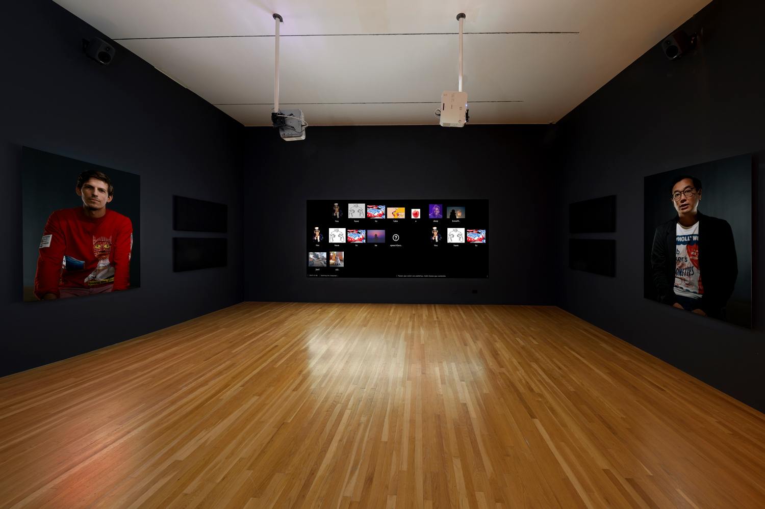 Art gallery room with wooden floor, dark walls, two portraits on either side, and a screen displaying various digital images.