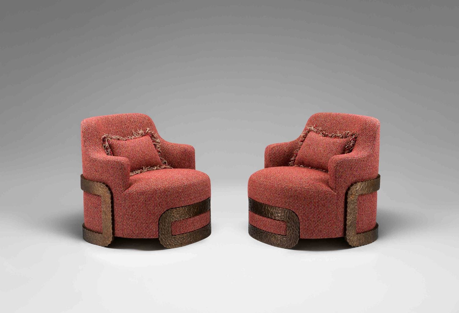 Two red modern chairs with textured fabric, featuring wooden accents and matching cushions, positioned on a neutral background.