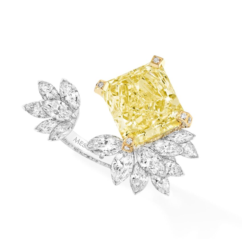 Yellow gemstone ring with diamond leaf design on white background.