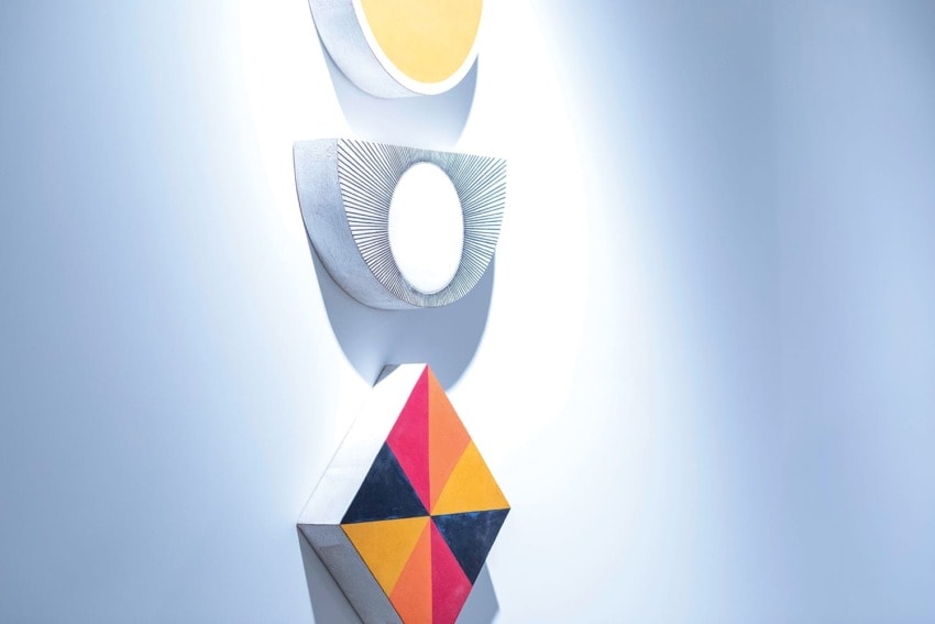 Geometric wall art with circular, semicircular, and diamond shapes in yellow, white, and multicolored patterns.