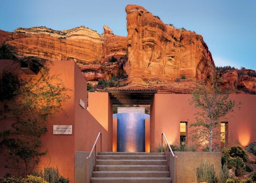 Staircase leading to a modern building with red rock formations in the background under a clear blue sky.