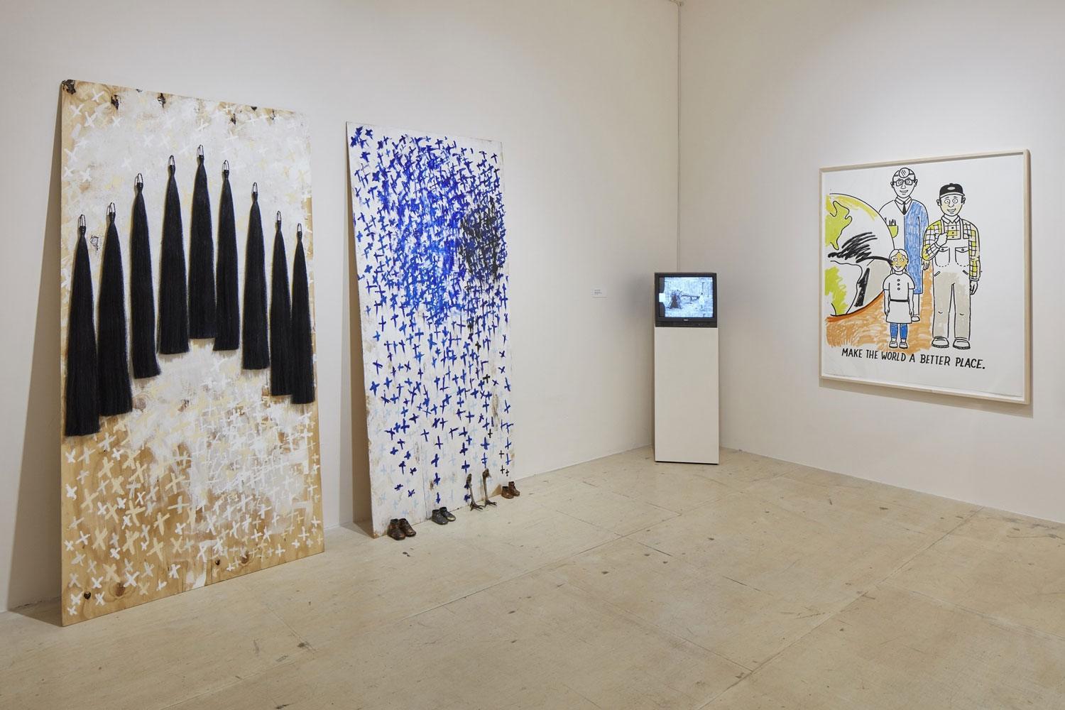 Art exhibition with three paintings and a small TV display on a pedestal in a gallery setting.