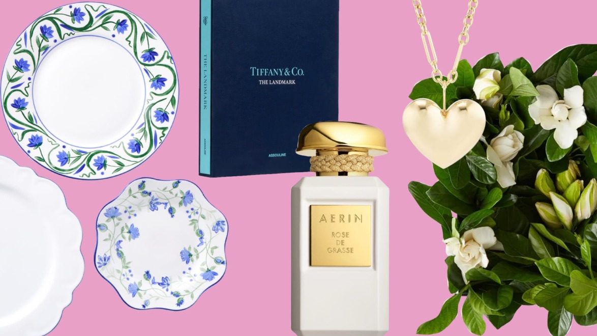Various decorative plates, a book, a perfume bottle, a heart-shaped necklace, and white flowers on a pink background.