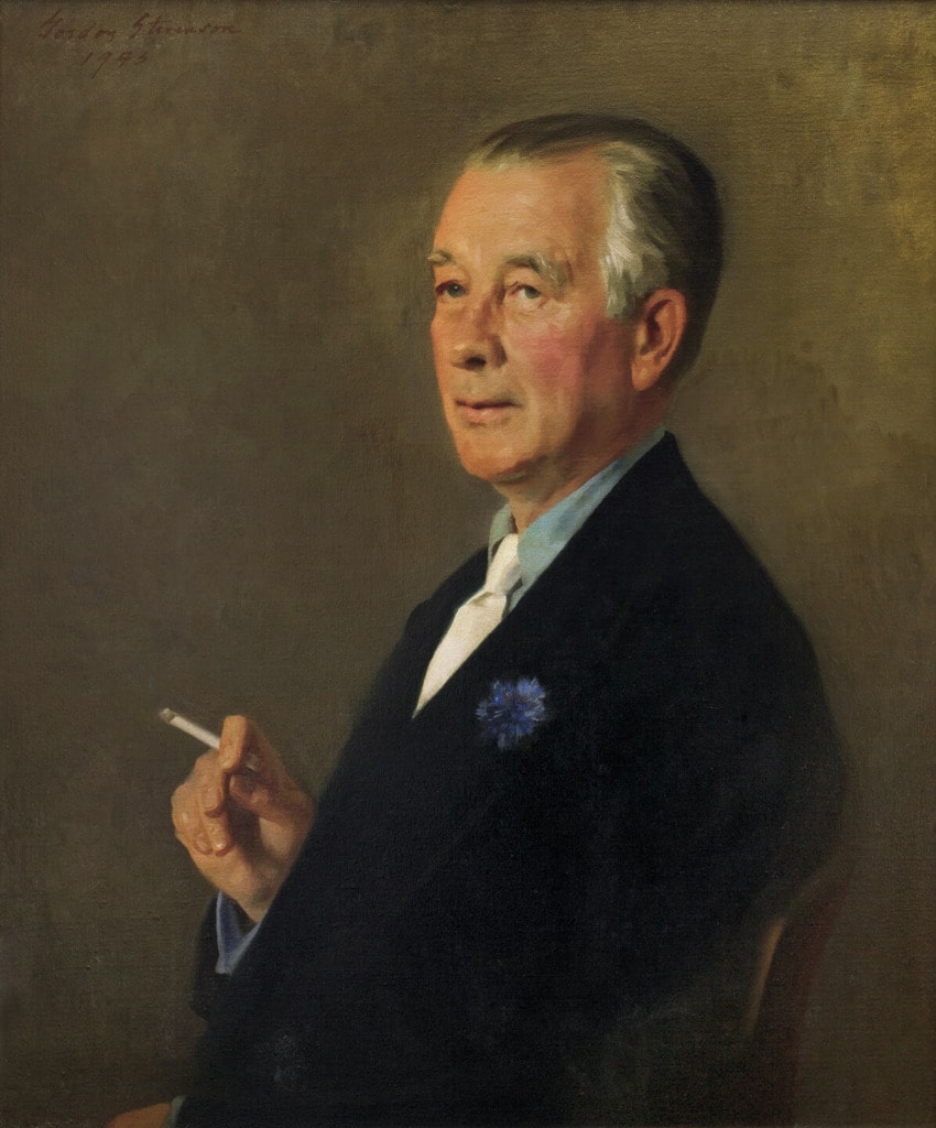 Portrait of a seated man holding a cigarette, wearing a suit and blue flower on his lapel, against a brown background.