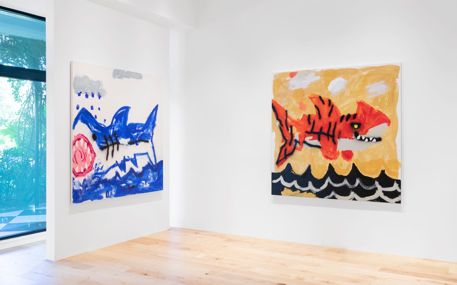 two colorful abstract shark paintings on display in a bright art gallery with a wooden floor