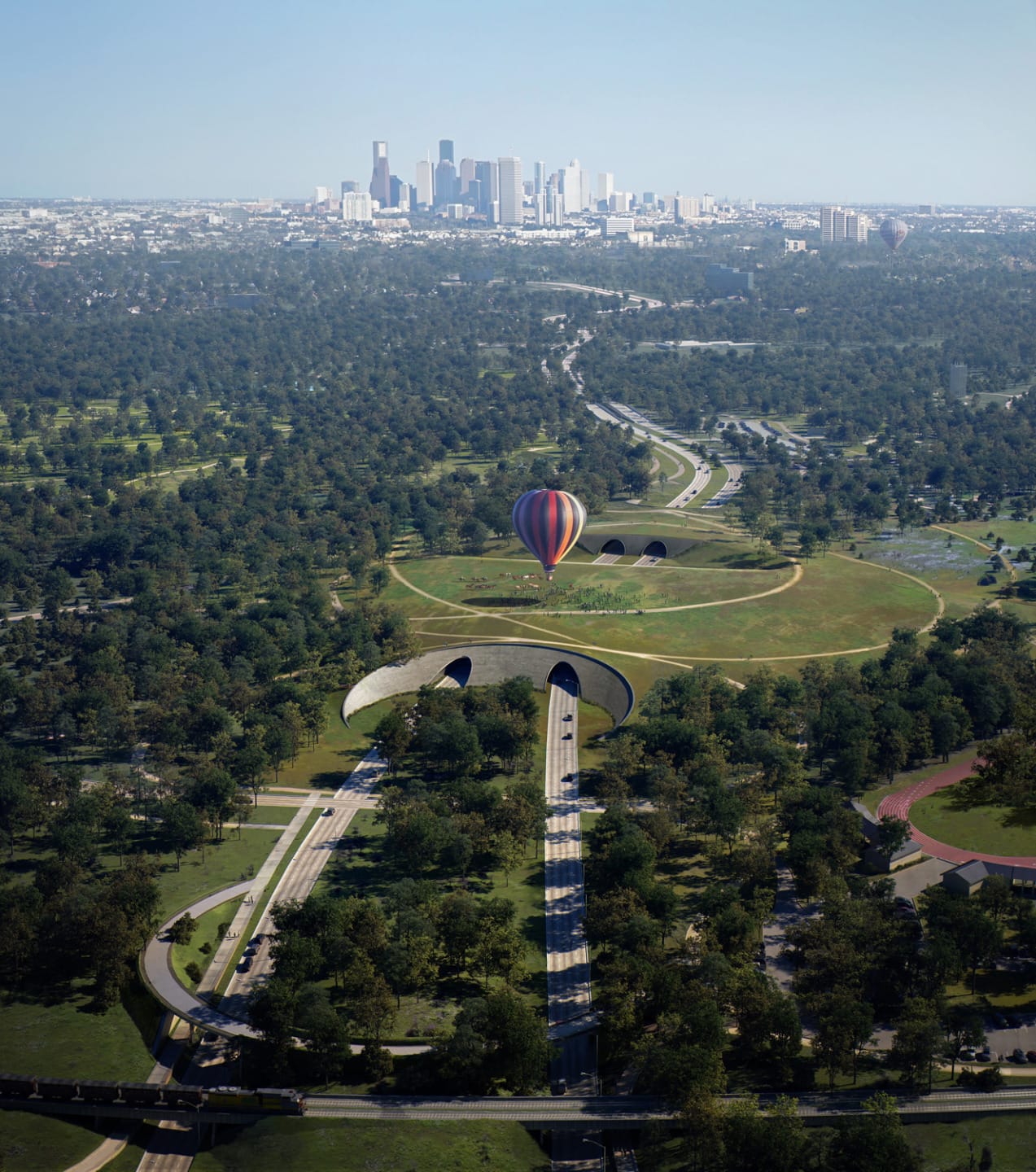 Hot air balloon floating over a verdant park with lush trees, pathways, and a distant city skyline in the background.