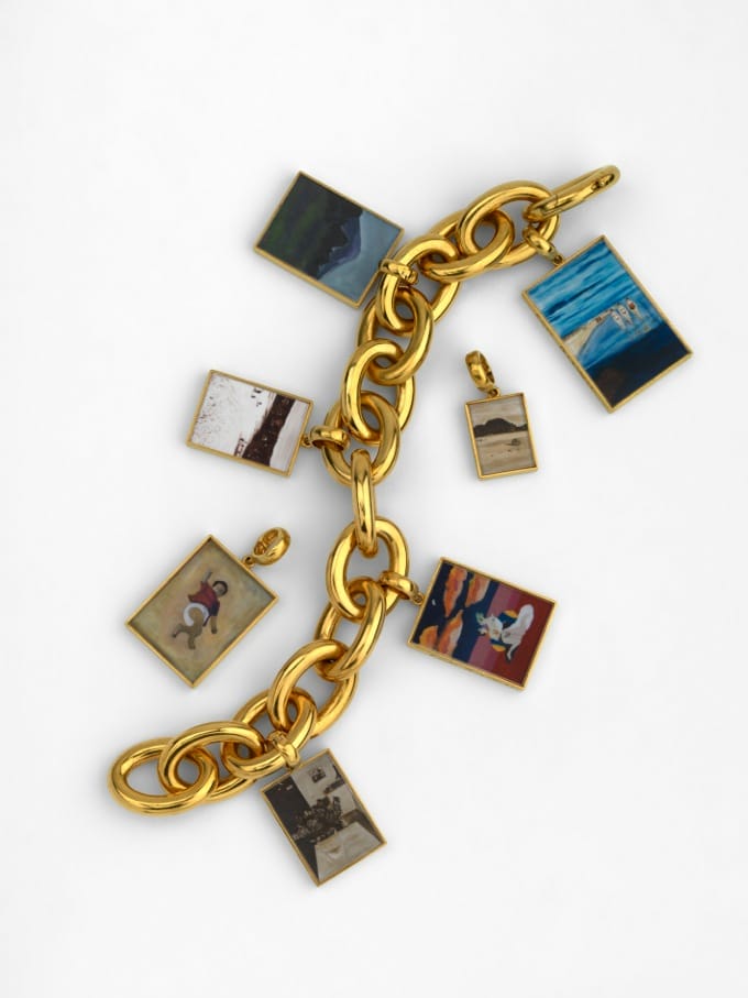 Gold chain bracelet with rectangular charms featuring various colorful artwork on a white background.