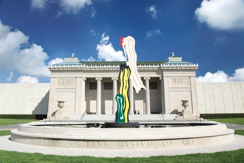 Outdoor sculpture at New Orleans Museum of Art with a clear blue sky and the museum building in the background.